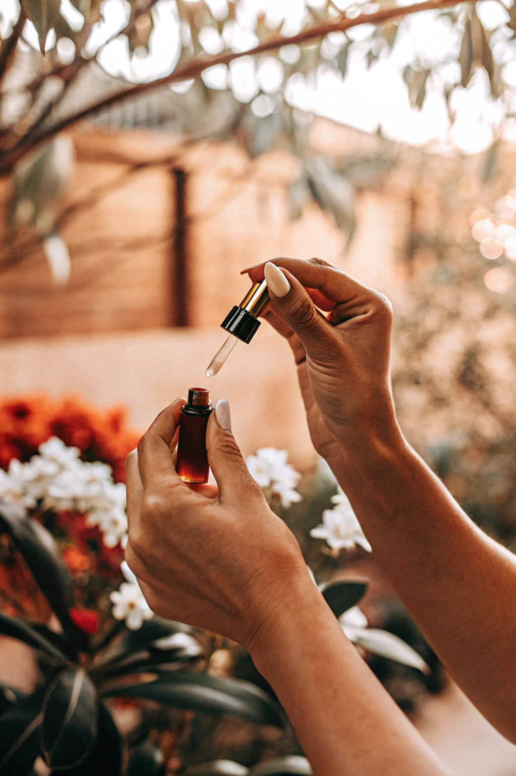 Hands holding essential oil bottle in natural setting